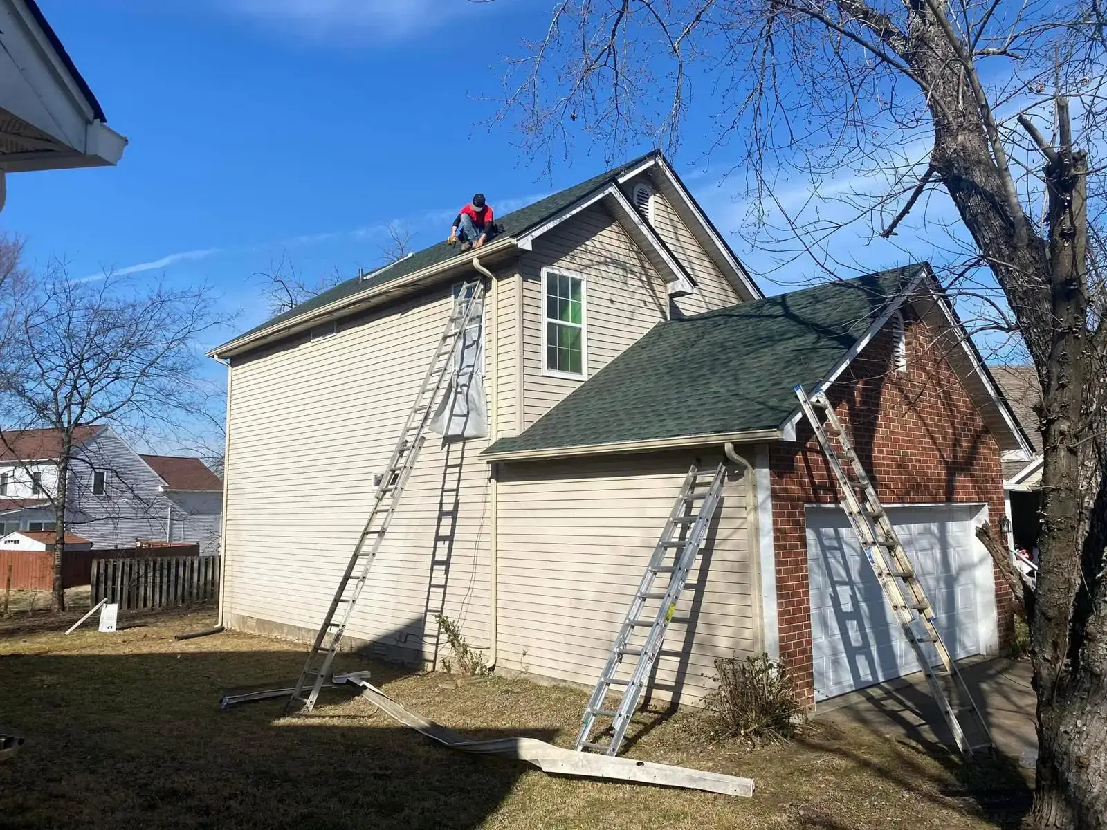 Crew working on siding and roofing of a two-story home