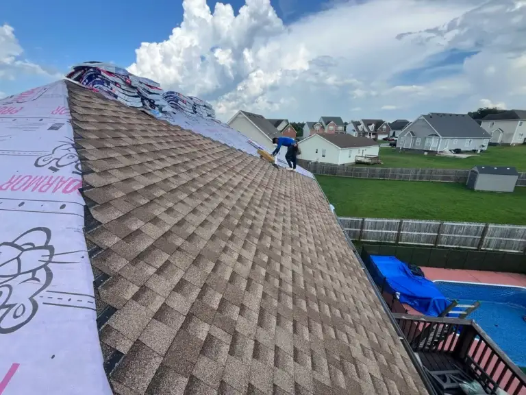 Roofer installing new shingles over underlayment