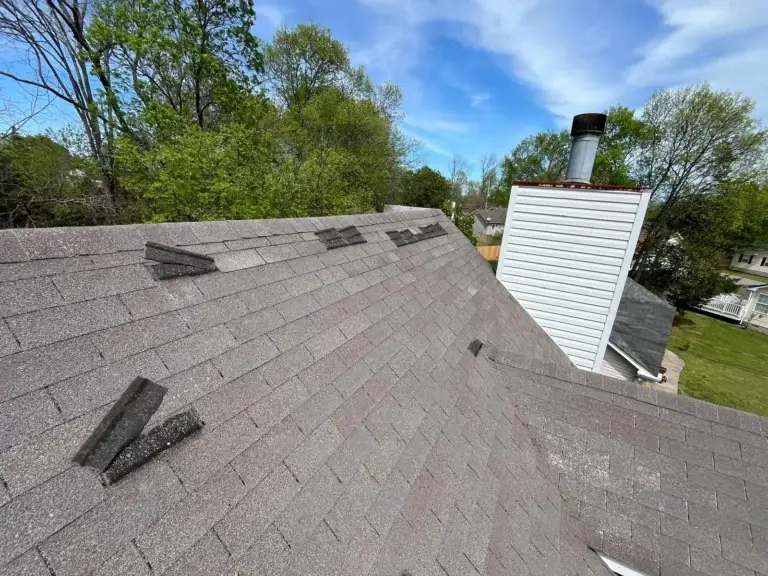 Storm-damaged asphalt shingles on a home roof