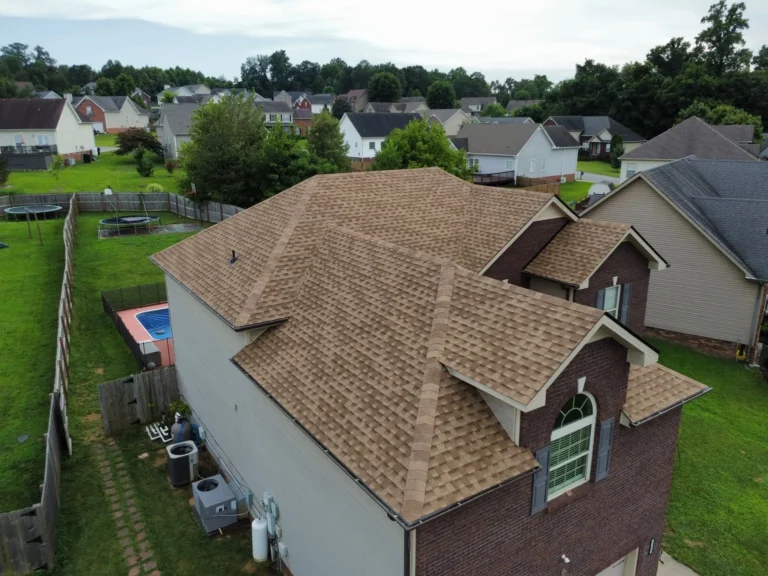 Aerial view of a new tan shingle roof on a brick home