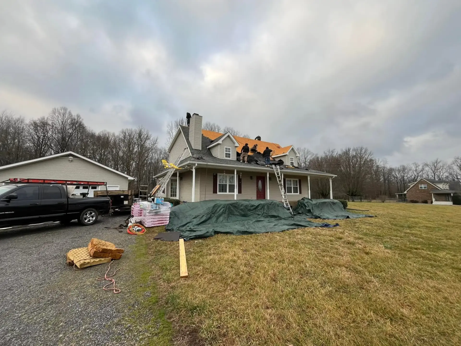 Roofing crew replacing the roof on a two-story home