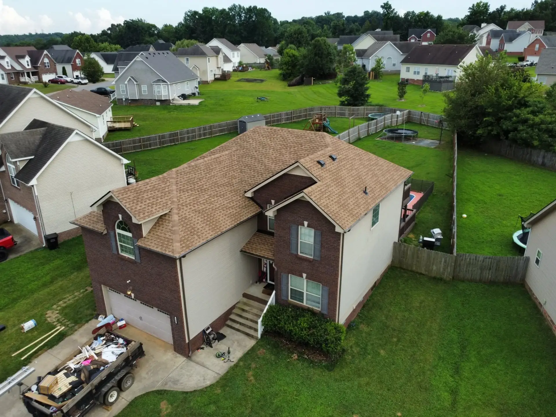 Aerial view of a newly roofed home in a residential neighborhood