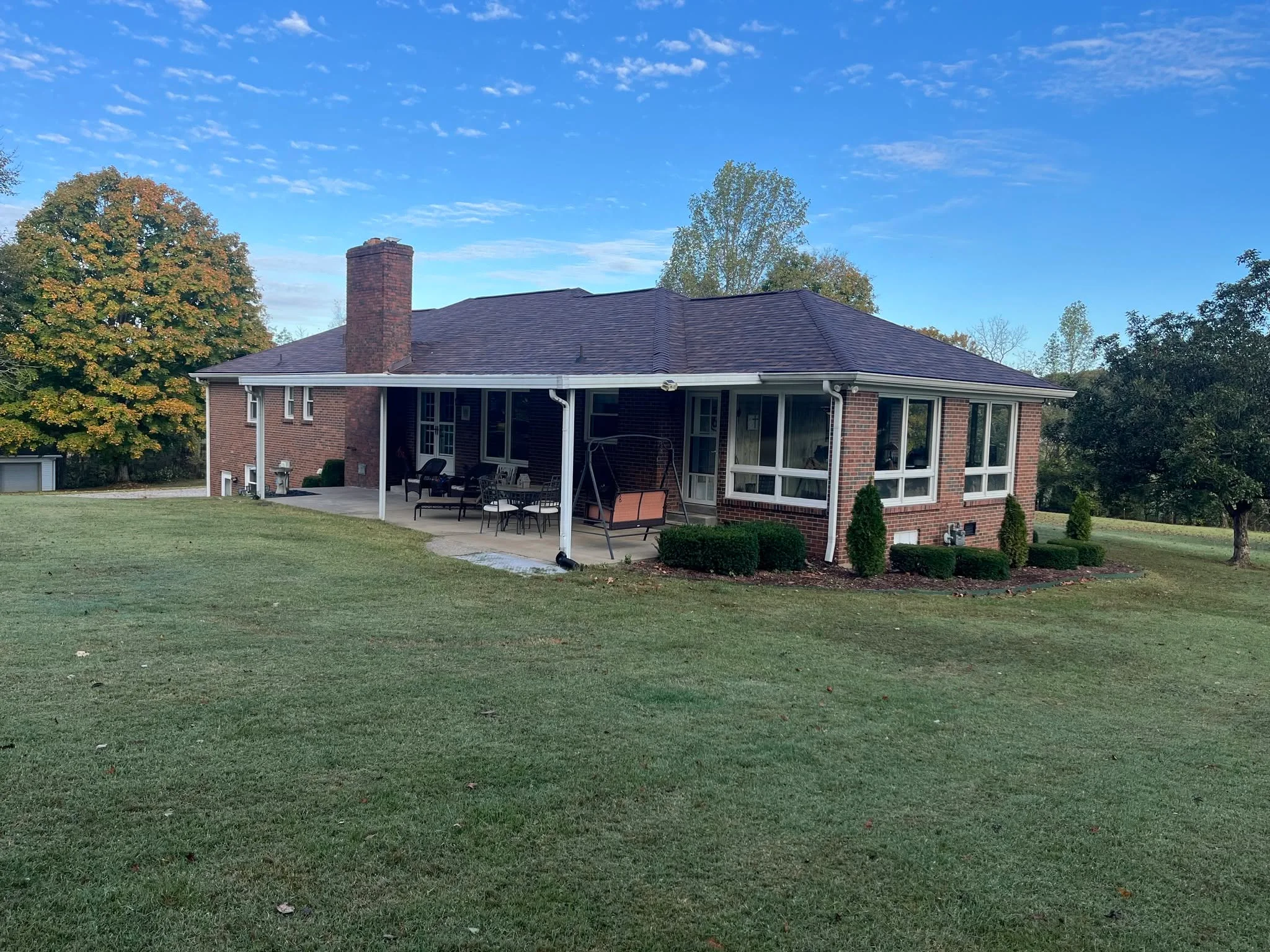 Brick home with a new roof seen from the backyard