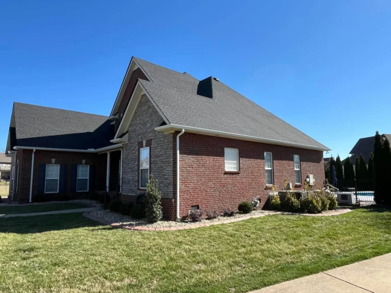 Brick and stone home with a newly installed shingle roof