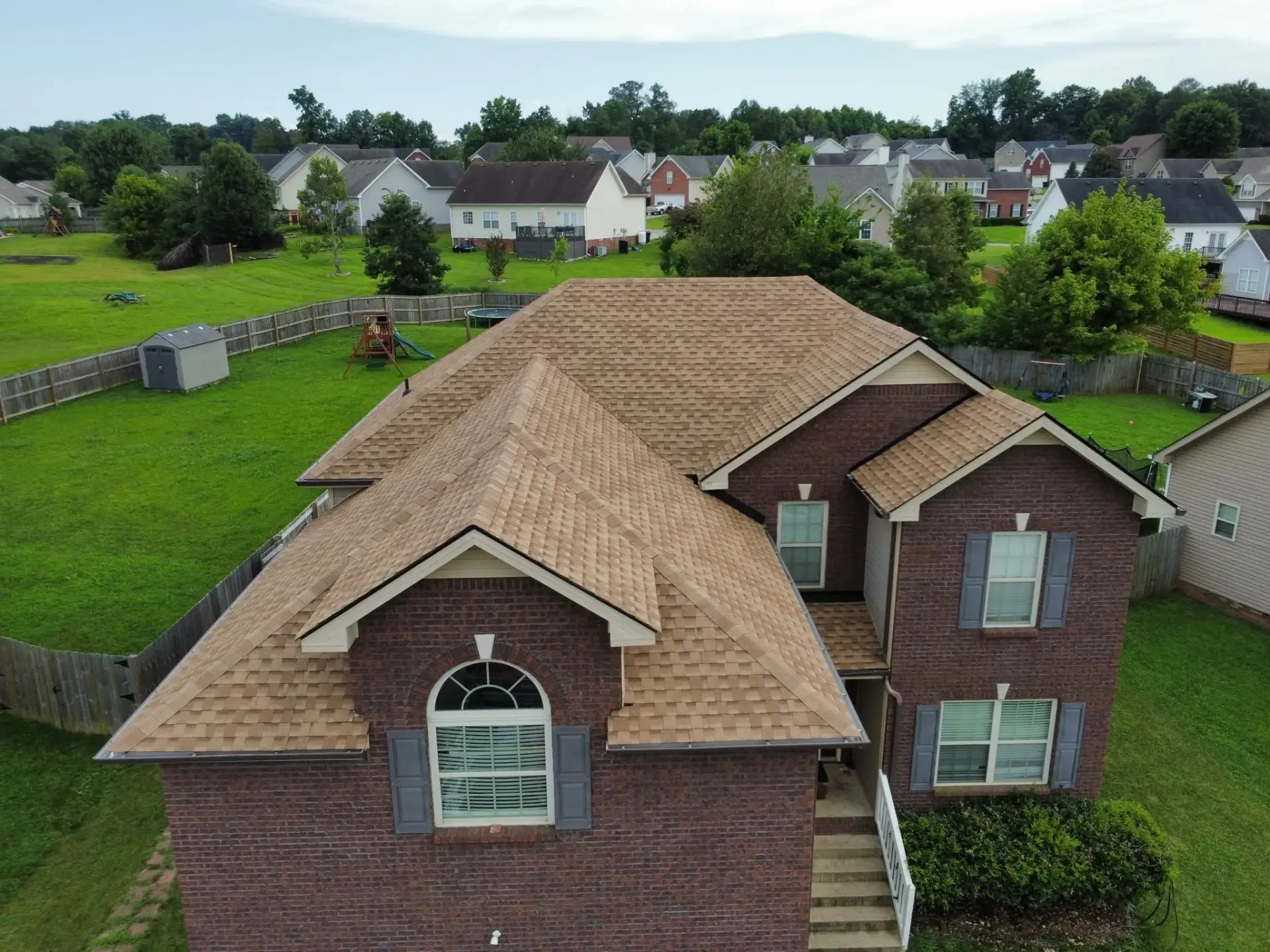 Brick home with a new shingle roof seen from above